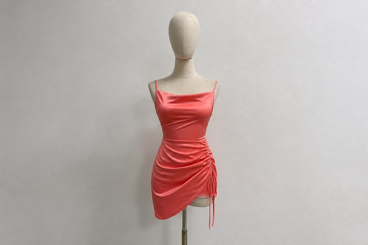 Coral satin mini dress on mannequin for custom dress manufacturing