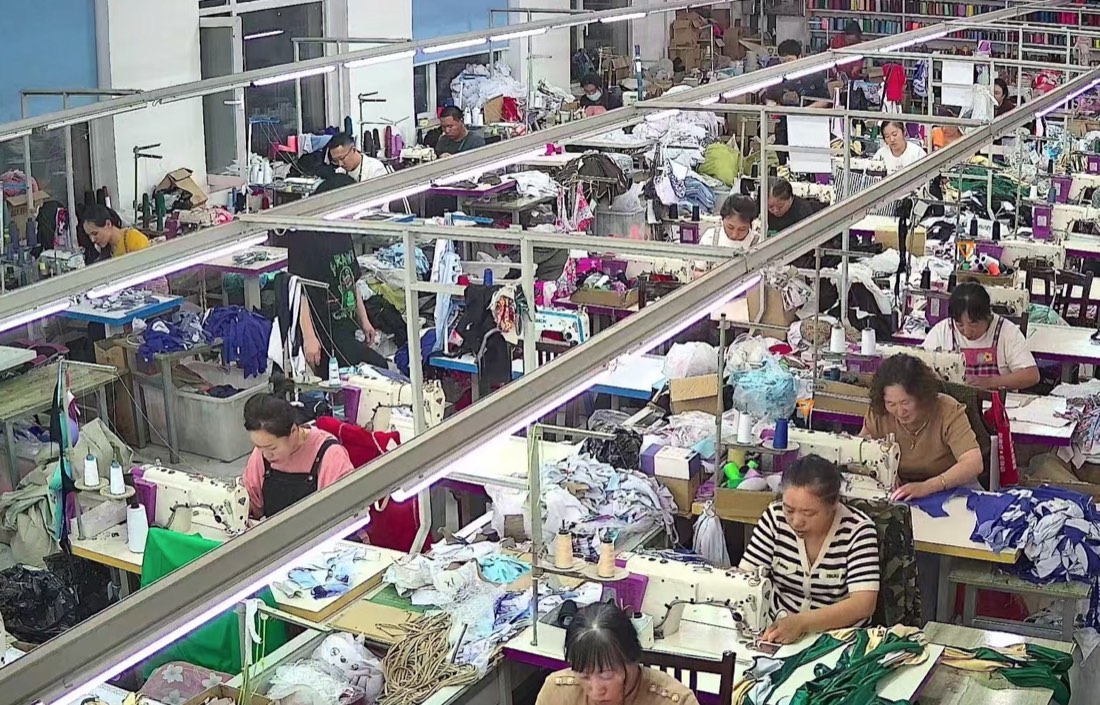 Guangzhou garment factory sewing room with womenswear production workers